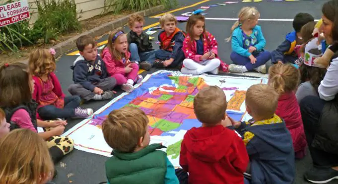 A group of children sitting around a map.
