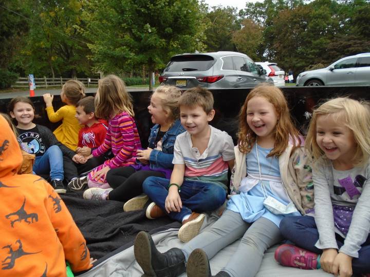 A group of children sitting in the back of a truck.